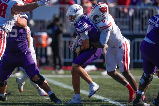 Wisconsin linebacker John Pius tackles Northwestern quarterback Jack Lausch during the first half of an NCAA college football game Saturday, Oct. 19, 2024, in Evanston, Ill. (AP Photo/Erin Hooley)