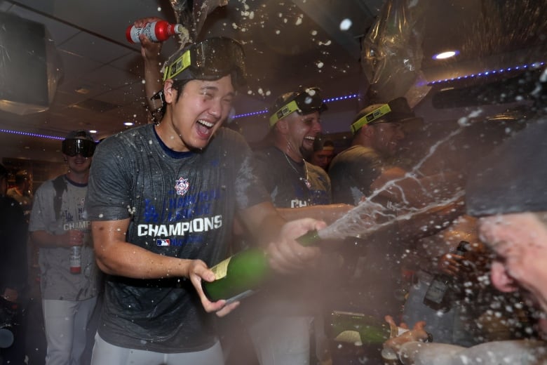 A man sprays champagne.