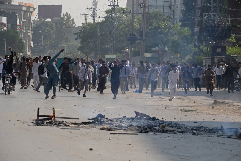 Students hurl stones towards security personnel during a demonstration