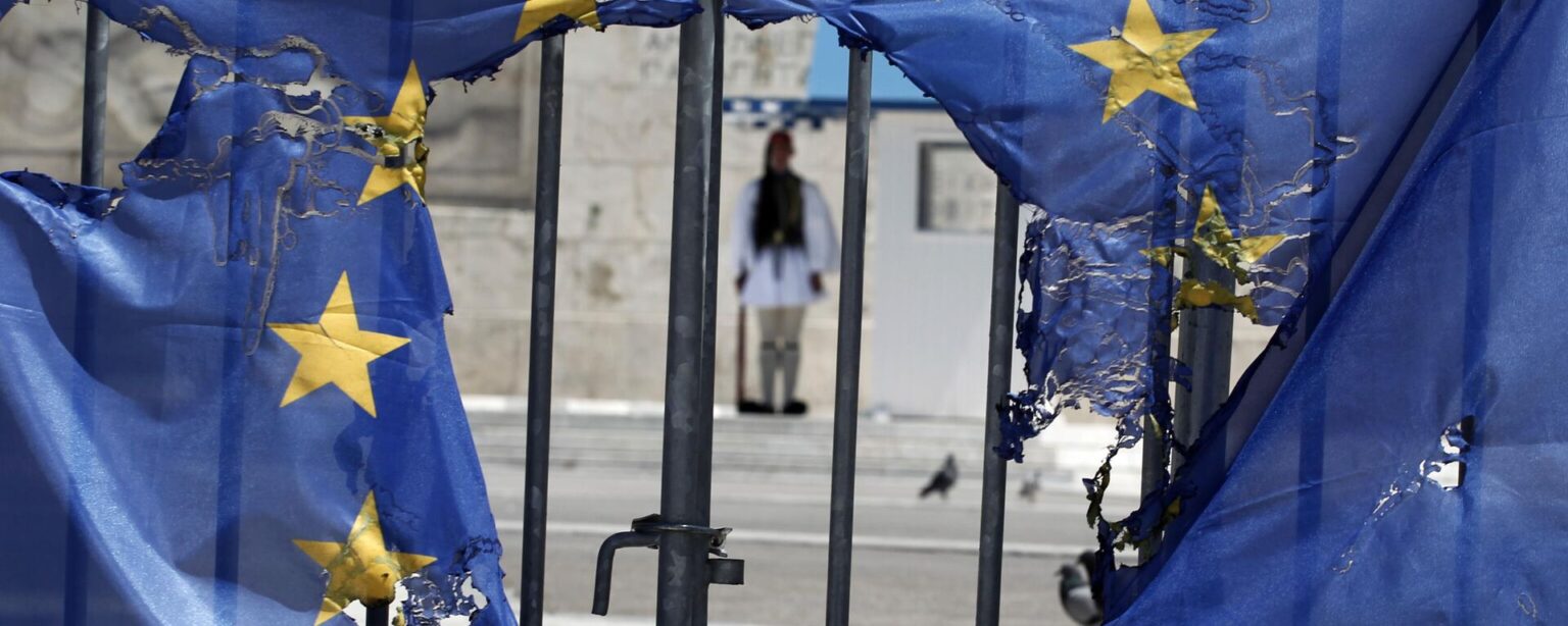 A Greek presidential guard stands framed bythe remains of a European Union flag half-burnt by protesters in Athens, on Wednesday, May 1, 2013 - Sputnik International, 1920, 15.10.2024