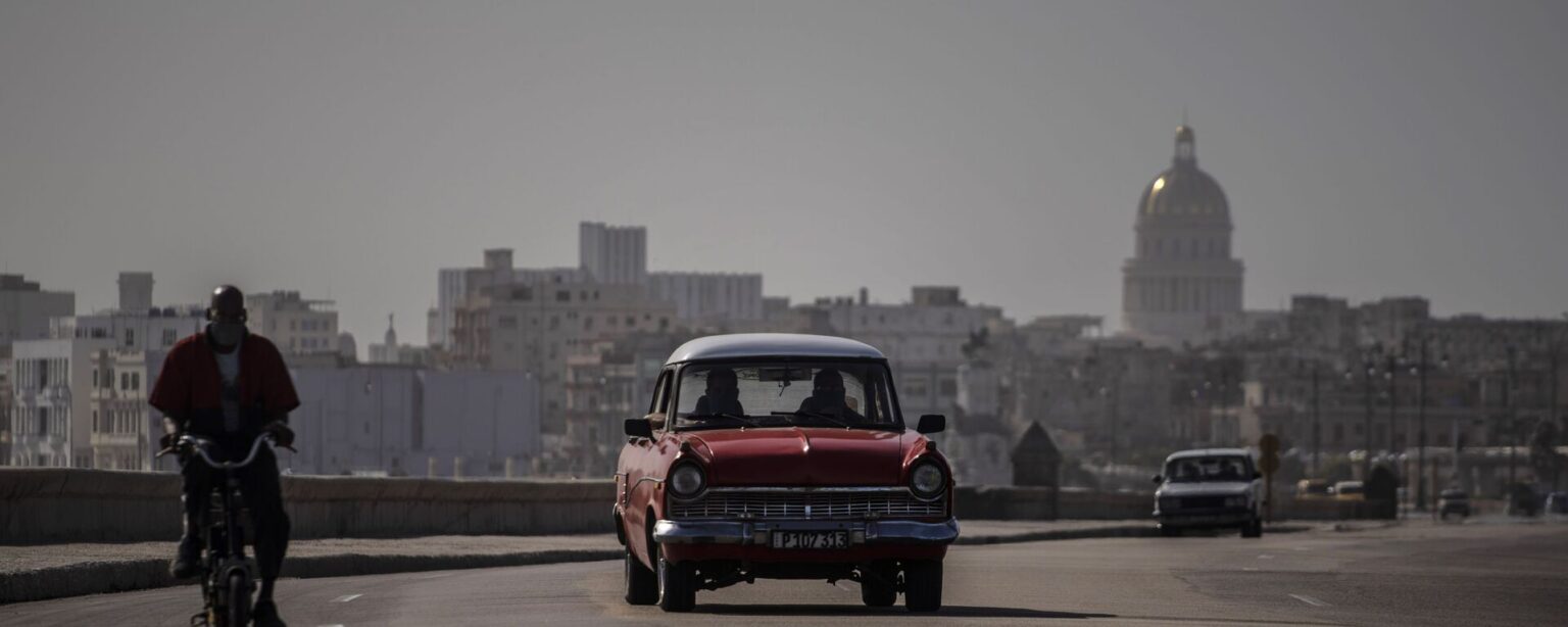 An American classic car and bicycle share the road on the Malecon amid a cloud of Sahara dust in Havana, Cuba, Thursday, June 25, 2020.  - Sputnik International, 1920, 20.10.2024