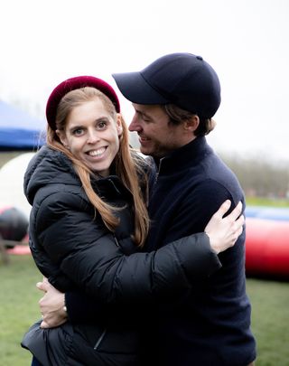 Princess Beatrice and Edoardo Mapelli Mozzi wearing coats and hugging