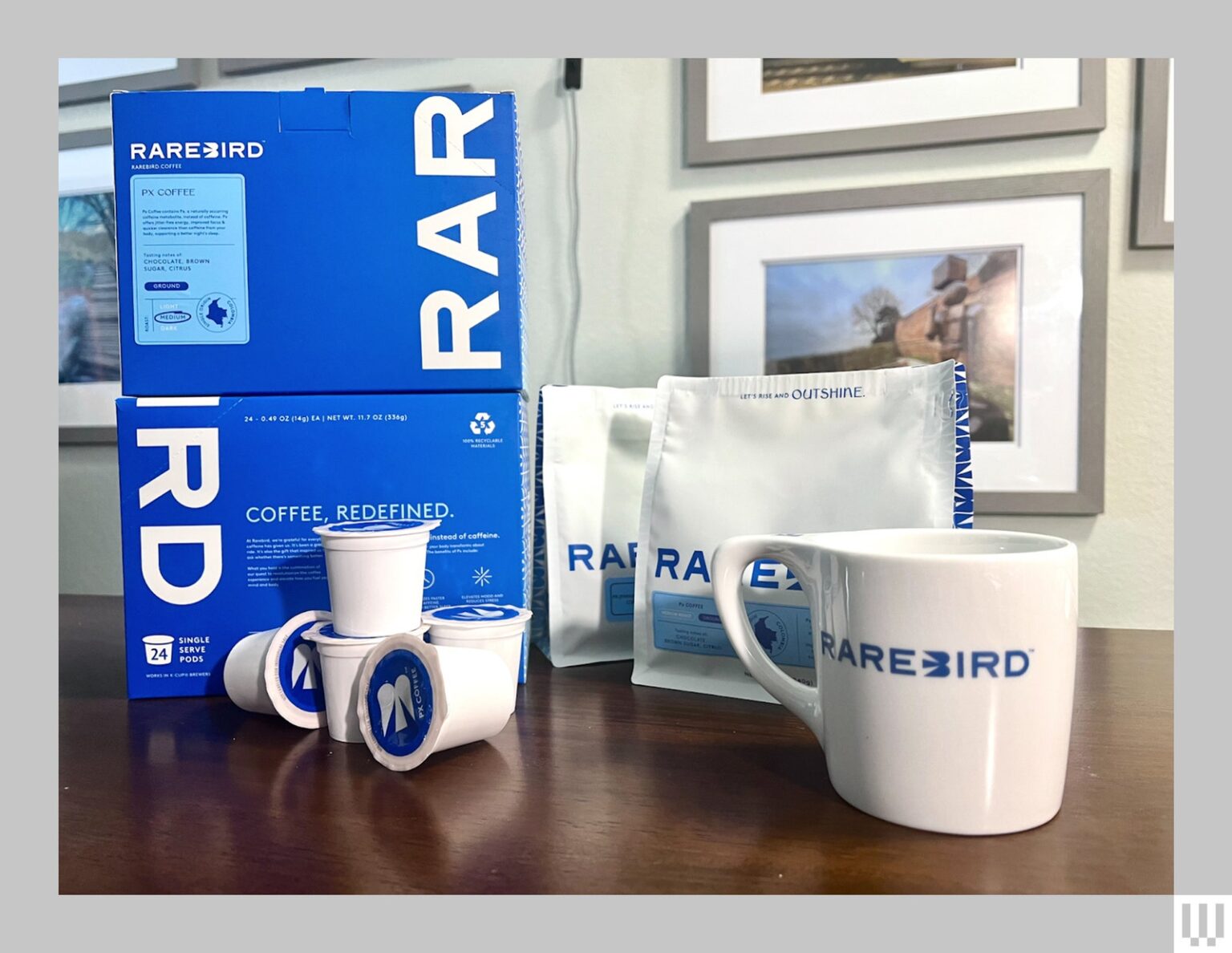 Packaging for Rarebird PX Coffee sitting on a wooden surface 2 stacked blue boxes white plastic containers 2 white bags...