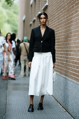 Woman at Fashion Week walking in the street wearing loafers,