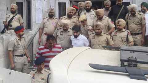 Lawrence Bishnoi, in white shirt, amid heavy police security while coming out of the Amritsar court complex on October 31, 2022 in Amritsar, India