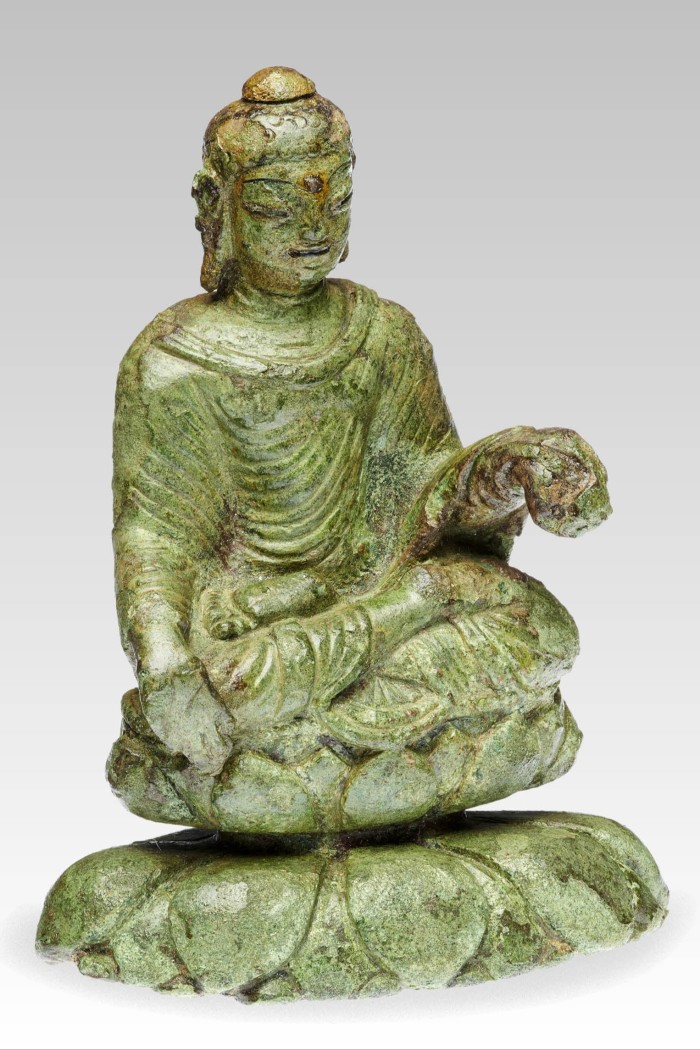 A small statue of a seated Buddha made out of metals