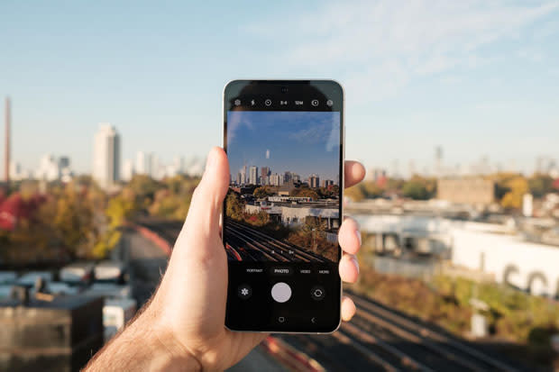 Image of the Galaxy S24 FE held in portrait mode with the camera activated in front of a nice view of somewhere in Canada.