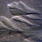 A satellite photo of gullies on Mars with ice around their edge