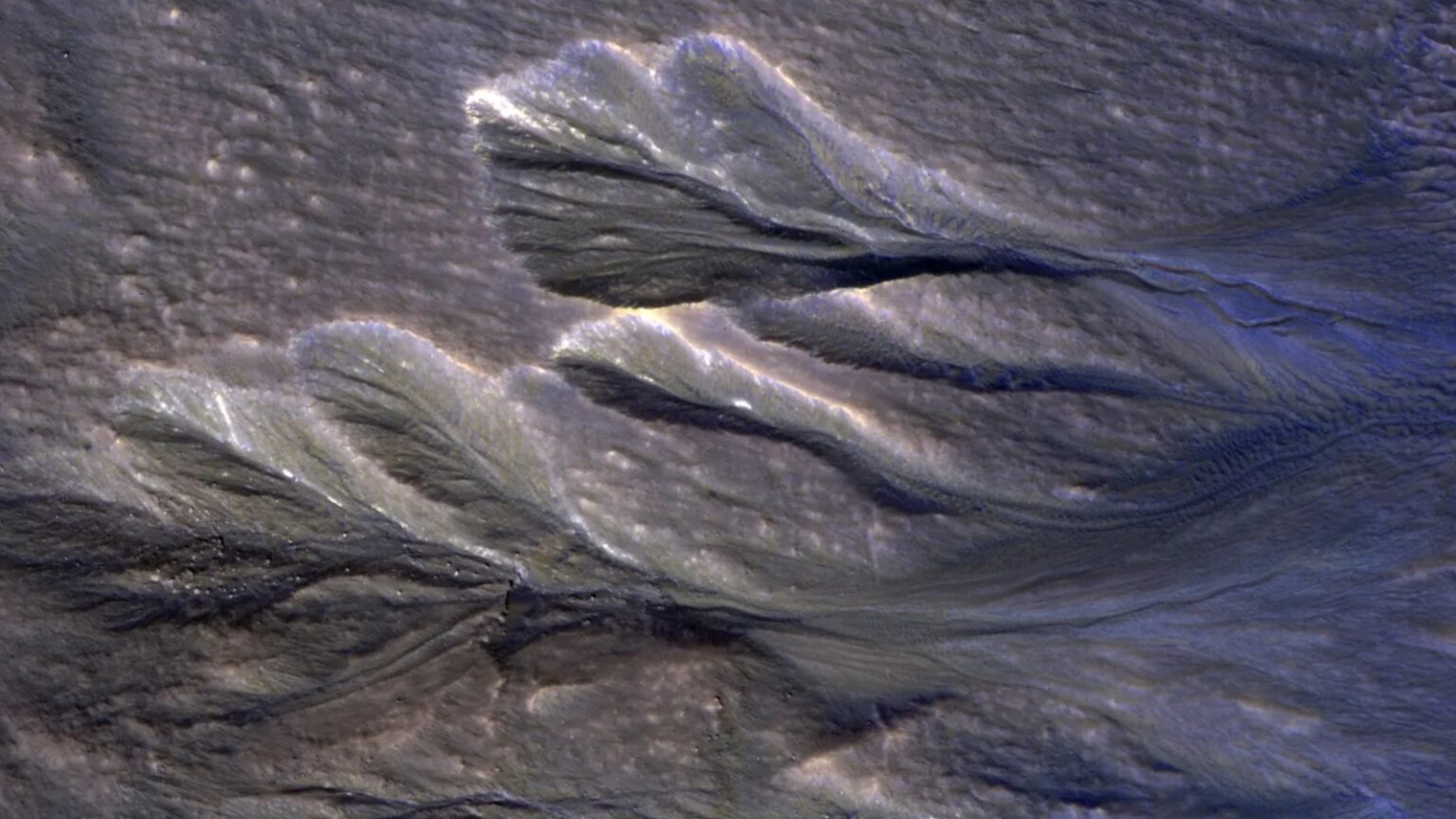 A satellite photo of gullies on Mars with ice around their edge