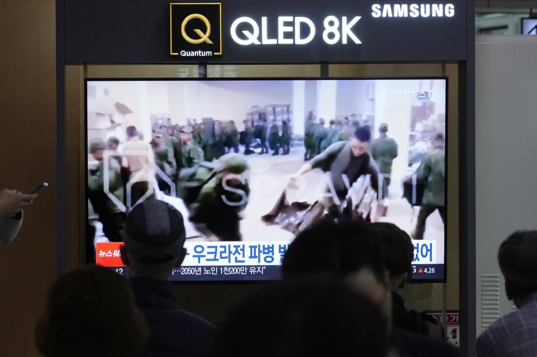 A TV screen shows an image of soldiers believed to be from North Korea stand in line to receive supplies from Russia during a news program at Seoul Railway Station in Seoul, South Korea, Monday, Oct. 21, 2024.