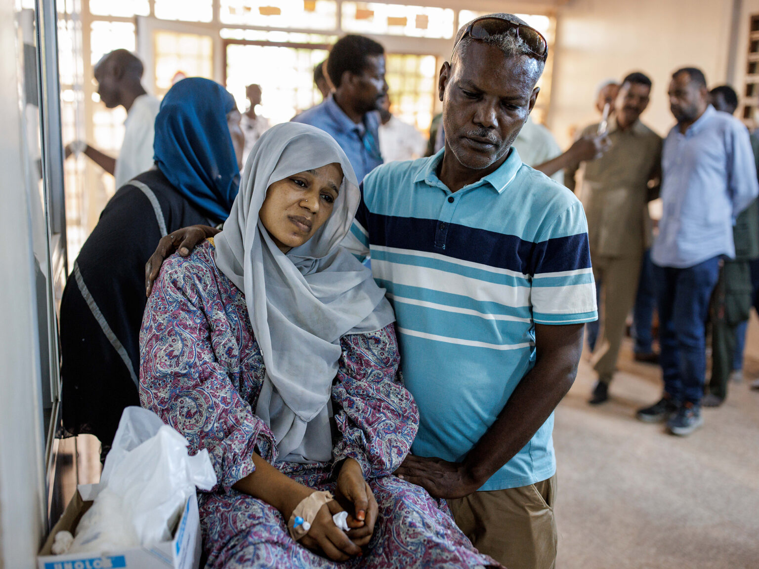 A husband comforts his wife, injured by shelling, in a corridor at the Al Nao Hospital in Omdurman, Republic of the Sudan on September 5.