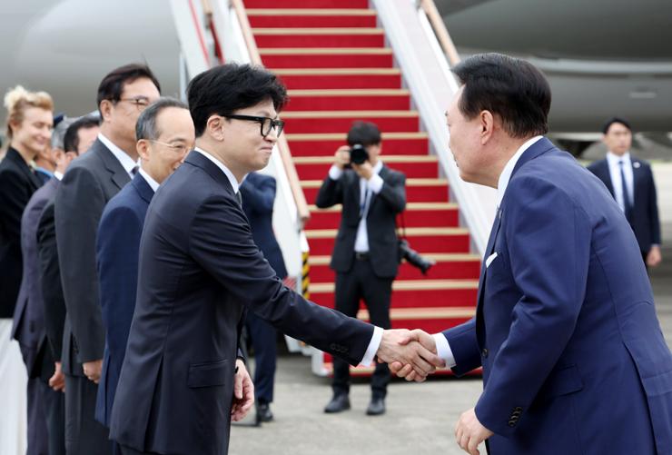 President Yoon Suk Yeol shakes hands with Han Dong-hoon, chairman of the ruling People Power Party, ahead of his departure for the Czech Republic from Seoul Air Base in Seongnam, Gyeonggi Province, Sept. 19. Yonhap