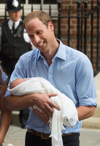 Prince William holding Prince George outside the hospital in 2013