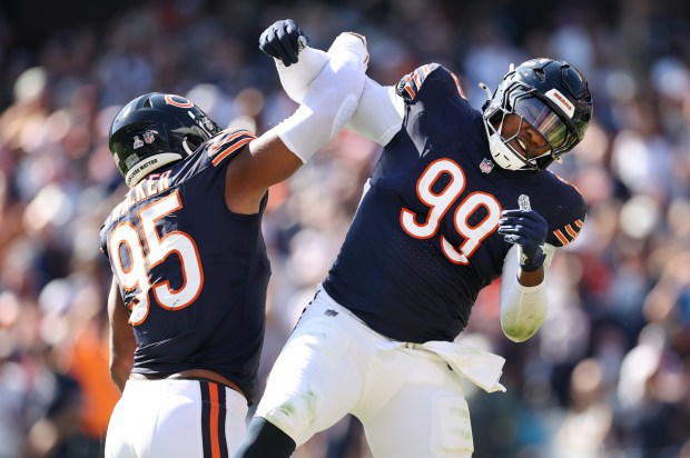 Chicago Bears defensive tackle Gervon Dexter Sr. (99) celebrates with teammate DeMarcus Walker (95) after Dexter Sr. recovered a fumble in the second quarter of a game against the Carolina Panthers at Soldier Field in Chicago on Oct. 6, 2024. (Chris Sweda/Chicago Tribune)